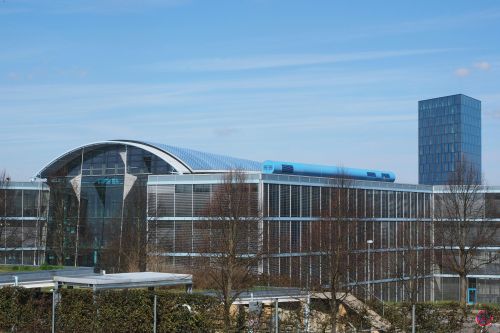A contemporary office building with a glass facade under a clear blue sky.